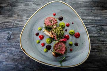 top view on exquisite decorated three raw grilled meat pieces