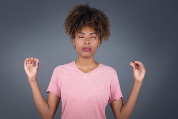 Meditation, religion and spiritual practices. Beautiful young African American female doing yoga in...