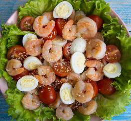 Salad with fried shrimp, quail eggs, cherry tomatoes and herbs