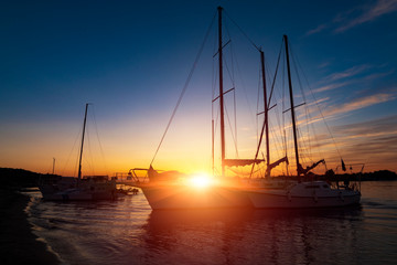 Holiday vacation travel concept: Holiday vacation sunset sunrise Sail boat Yacht at quay. Nautical, relaxation