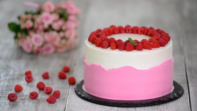 Cake with whipped pink cream, fresh raspberry and mint.