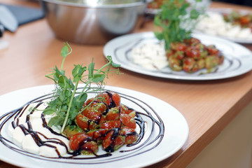 Caprese salad with pesto and herbs for decoration