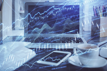 Financial chart drawing and table with computer on background. Double exposure. Concept of international markets.