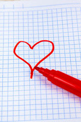 Red heart is drawn on a checkered sheet.