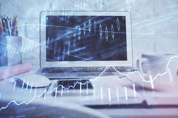 Stock market graph and table with computer background. Double exposure. Concept of financial analysis.