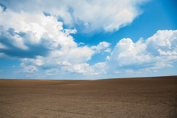 Plakat Empty brown soil of field and blue sky for natural background