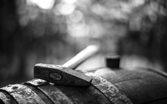 Wine making hammer on the old wine barrel in the vineyard, winery, Hungary in Monochrome