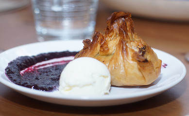 Dough cake on a plate with a scoop of ice cream and sauce
