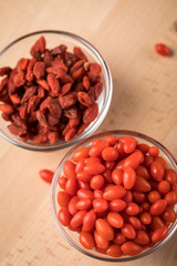 Frische und getrocknete Goji-Beeren Superfood in Glas Schale auf Holz Brett Hintergrund