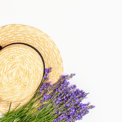 Summer fashion composition. Fresh flowers of purple lavender, women's summer straw hat on light gray background. Flat lay top view copy space. Lavender floral background flower card. Female accessory