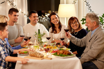 celebration, holidays and people concept - happy family having dinner party, drinking red wine and toasting at home