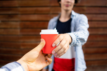 giving  a cup of fresh hot espresso, two hands deliver and recieve, buying coffee
