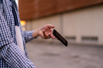 person holding a smartphone in the street, a phone falling and flying  down by an accident