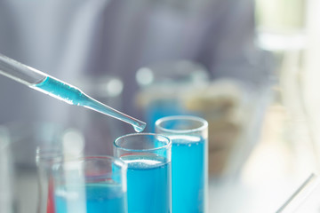 Researcher with glass laboratory chemical test tubes with liquid for analytical , medical, pharmaceutical and scientific research concept.