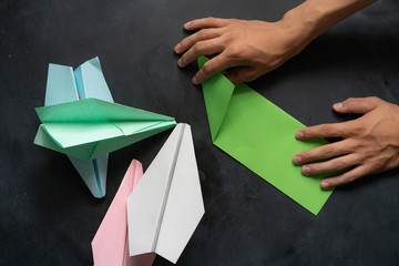 person hands making a origami color paper plane