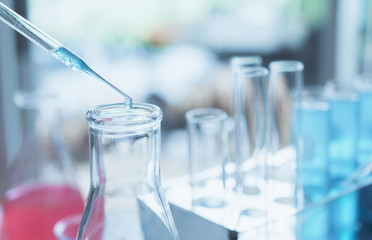 Researcher with glass laboratory chemical test tubes with liquid for analytical , medical, pharmaceutical and scientific research concept.