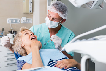 male dentist with female patient during checkup in dentistry