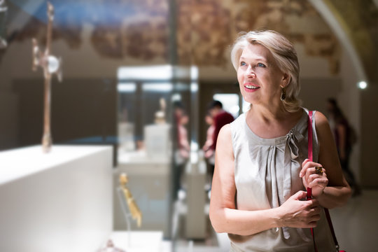 Mature woman near the ancient exhibit