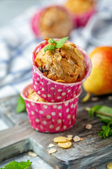 Freshly baked muffins with pear in paper forms.