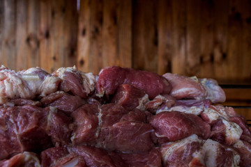 Large pieces of fresh beef against a wooden wall