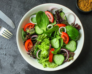 Healthy salad, leaves mix salad (mix micro greens, cucumber, tomato, onion, other ingredients). food background. copy space