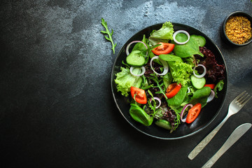 Healthy salad, leaves mix salad (mix micro greens, cucumber, tomato, onion, other ingredients). food background. copy space
