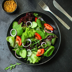 Healthy salad, leaves mix salad (mix micro greens, cucumber, tomato, onion, other ingredients). food background. copy space