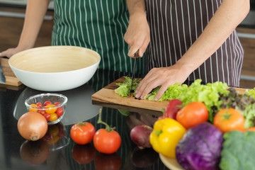 Young Asian couple preparing vegetable for make a fresh salad for their lunch