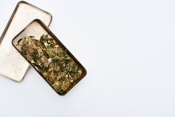 top view of Marijuana Buds in metal case on white background