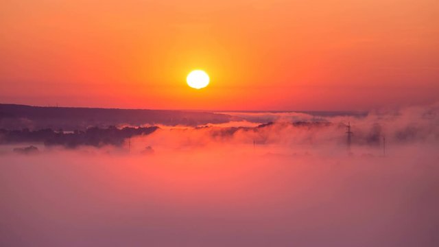 Timelapse of sunrise on misty valley