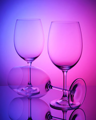Transparent wine glass on purple background