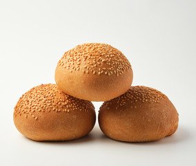 stack of baked whole round bun with sesame seeds