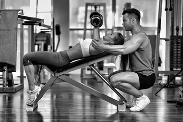 Poster Personal trainer helping woman at gym © Xalanx