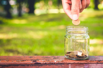 businessman putting coin in to glass jar count the money for saving concept. budgeting for investment startup business.