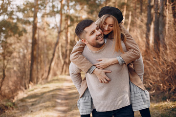 Fototapeta premium Couple in a park. Blonde in a brown coat. Man with a beard