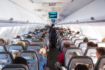 Binnenzicht op passagiers en cabinepersoneel op een vliegtuig van een luchtvaartmaatschappij tijdens vluchtvakantie. Transport toerisme luchtvaart concept