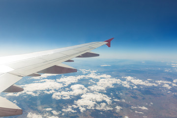 Obraz premium Wing of an airplane. Traveling concept. Aircraft wing on the clouds