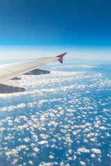 Obraz premium Wing of an airplane. Traveling concept. Aircraft wing on the clouds