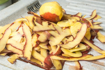 Purified skin of good potatoes with special knife on sink.