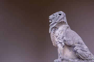 Imposante Statue eines mächtigen Löwem mit muskulösen Vorderbeinen und schöner Mähne aus Stein...