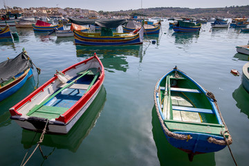 Fototapeta na wymiar Marsaxlokk. Traditional boats Luzzu in the old harbor.