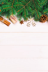 Christmas background with fir tree and gift box on wooden table. Top view with copy space for your design. Toned