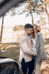 Couple in a park. Blonde in a gray jacket. Man with a beard