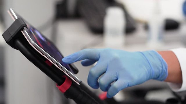 Medical Research Scientist working with data on tablet in High Tech Laboratory
