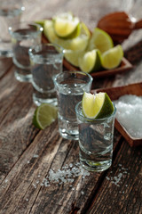 Tequila with  salt and lime on a old wooden background.