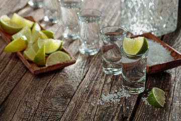 Tequila with  salt and lime on a old wooden background.