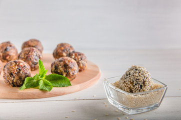 vegetarian food, energy balls of walnuts, dates, prunes, cranberries, honey with sesame