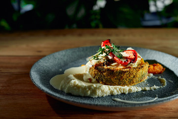 Breaded fish served with tasty puree and grilled vegetables
