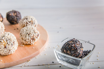 vegetarian food, energy balls of walnuts, dates, prunes, cranberries, honey with sesame