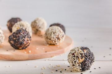 vegetarian food, energy balls of walnuts, dates, prunes, cranberries, honey with sesame